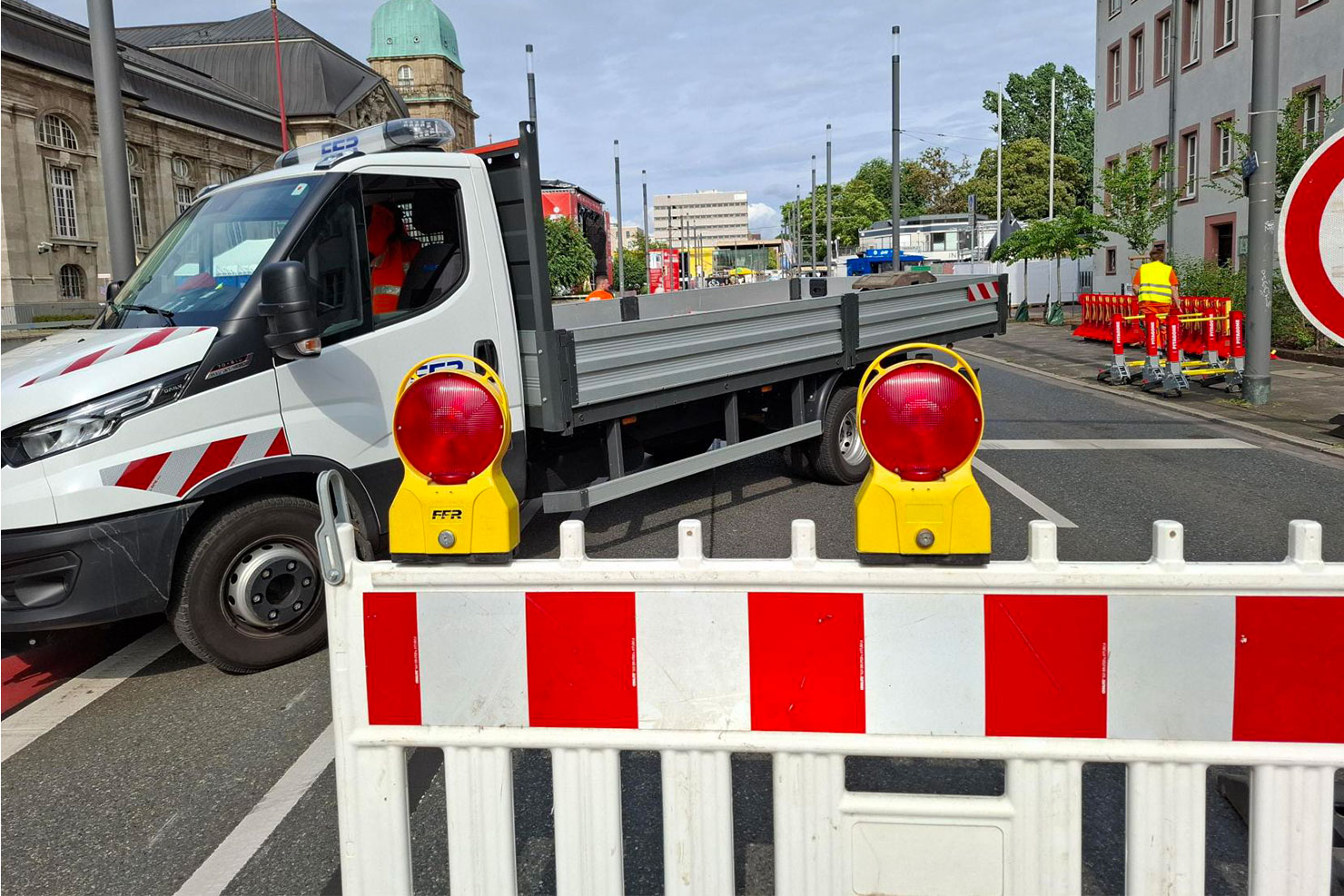 Transportfahrzeug der FFR hinter einem rot-weißen Absperrgitter mit Warnleuchten